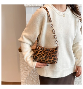 Detail of leopard print crescent bag showing chain strap and soft texture on model