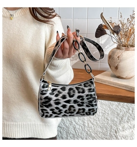 Detail of leopard print crescent bag with glossy finish and chain shoulder strap