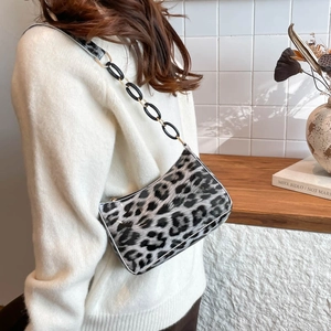 Vintage leopard print crescent underarm bag with gold chain strap worn by model
