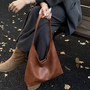 Retro brown leather tote bag with large capacity for women shown in an outdoor setting