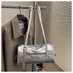 Detail of silver metallic cylindrical shoulder bag with double zipper and adjustable strap