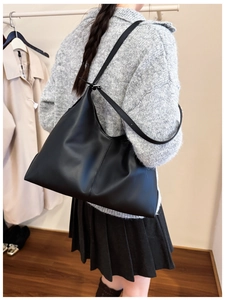 Detail of a black matte leather hobo bag showing the adjustable strap and large capacity