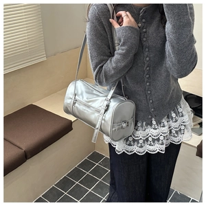 Metallic silver cylinder shoulder bag shown as a daily outfit accessory for women