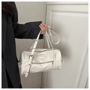 Detail of white leather barrel bag with silver eyelet strap and metallic rivets