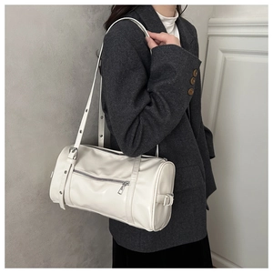 Detail of white cylinder shoulder bag in glossy PU leather with silver zipper pocket