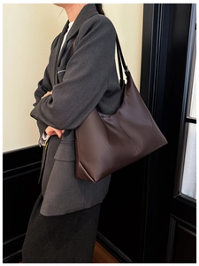 Brown matte leather tote bag worn by model, minimalist style for office and daily commute
