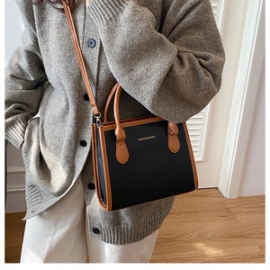 Model wearing a minimalist black and brown leather crossbody bag with FASHION & BAG logo