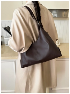 Detail of dark brown minimalist tote bag in soft leather with vertical stitching