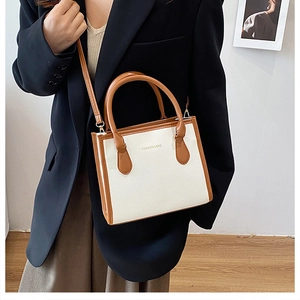 Fashionable white and brown leather crossbody bag styled with a professional black blazer