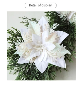 Detail of white artificial poinsettia with glitter petals and green pine branch decor