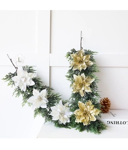 Detail of Christmas garland with faux pine needles, white and gold glitter flowers for decor