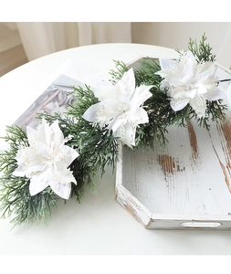 Close-up of artificial white poinsettia garland with glitter on white wooden tray