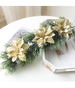 Detailed view of Christmas garland with gold glitter poinsettias and green pine branches