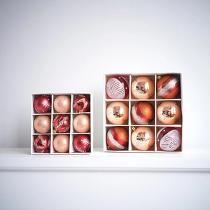 Red and gold Christmas ball ornaments set with glitter patterns in gift box packaging