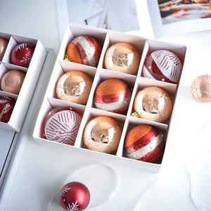 Detail of red and gold Christmas ball ornaments in a 9-compartment white display box