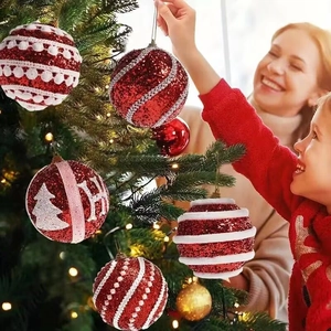 Red Christmas tree ornaments with white wave patterns and H letter in festive home setting
