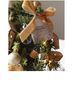 Macro view of festive ornaments with velvet bows, gold baubles, and warm LED light strings