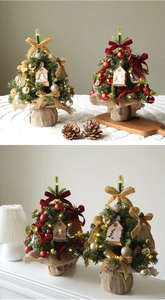 Detailed view of mini Christmas trees with warm LED lights and burlap bases