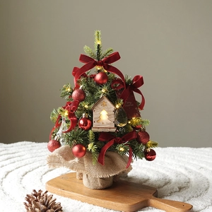 Mini PE artificial Christmas tree with red bows, wooden house, and burlap base