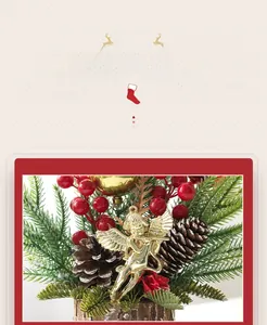 Detailed view of mini Christmas tree with gold angel, red berries, and pine cone on wood base