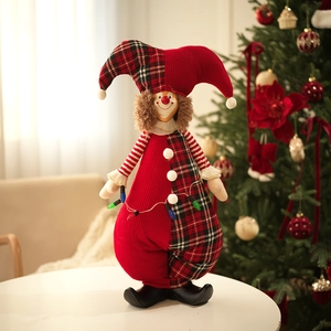 Close-up of a festive jester doll in red and black plaid on a white table decoration