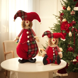 Detail of Christmas clown dolls in red and black plaid with festive lights and ornaments