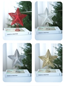 Detail of glittered star tree toppers in gold, red, silver, and white with spring base