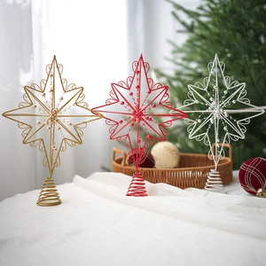 Detailed view of red, gold and white wire star tree toppers with spiral bases on a table