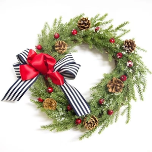 Christmas wreath with pine cones, red berries and a large red and blue striped bow