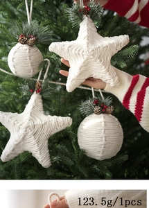 Detail of handmade white cotton star Christmas ornament with pine needles and berries