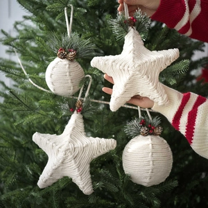 Detailed view of handmade rope Christmas balls and star ornaments on a tree branch
