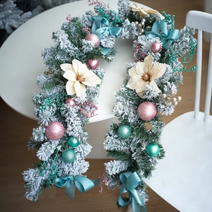 Détail de couronne de Noël enneigée de 40cm avec boules roses et fleurs dorées