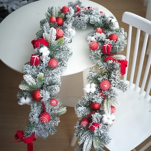Vue détaillée d'une couronne de Noël de 40cm avec boules rouges, nœuds et effet neige