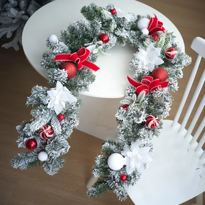 Détail d'une couronne de Noël de 40 cm avec nœuds rouges, épines enneigées et fleurs blanches