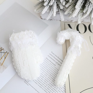 Vue détaillée d'une chaussette de Noël blanche et d'un sucre d'orge aux paillettes argentées