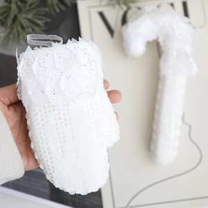 Détail de gants scintillants blancs et sucres d'orge avec dentelle et rubans