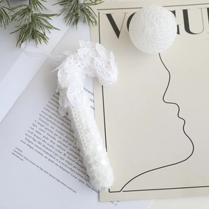 Vue détaillée d'un sucre d'orge blanc à paillettes pour sapin de Noël avec ruban de soie