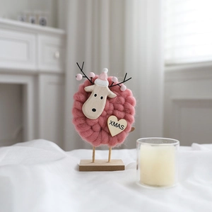 Detail of pink wool felt reindeer desktop ornament with XMAS tag and wooden base