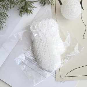 Détail de canne de Noël blanche avec paillettes et plumes dans son emballage festif