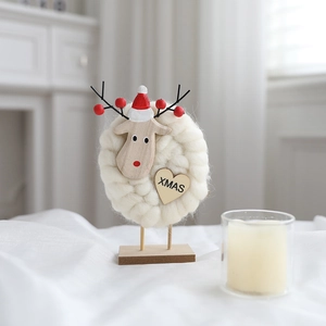 Detail of wool felt Christmas ornament with reindeer head and XMAS heart wooden tag