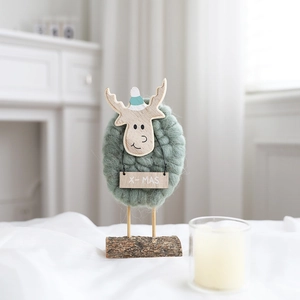 Detail of wool felt sheep figurine with X-MAS wooden sign and natural timber base