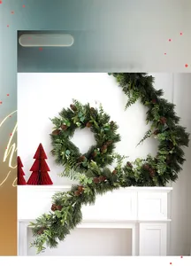 Close-up of artificial PE Christmas garland with pine cones and eucalyptus on a white mantel