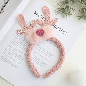 Λεπτομέρεια από ροζ κέρατα ταράνδου με παγιέτες και λούτρινη διακόσμηση σε στέκα