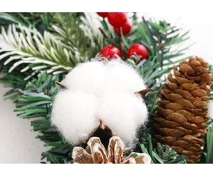 Vue détaillée de couronne de Noël avec pommes de pin, coton et baies rouges