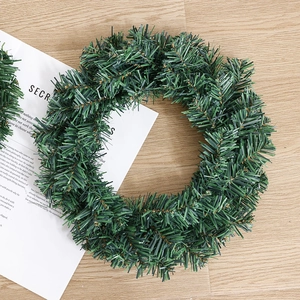 Classic green artificial PVC pine needle Christmas wreath on a rustic wooden floor
