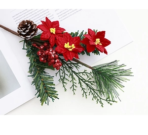 Gros plan de tiges de Noël avec fleurs de poinsettia, pommes de pin et baies rouges
