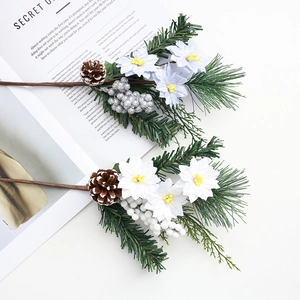 Branche de sapin de Noël réaliste avec pommes de pin baies et fleurs en tissu sur bureau