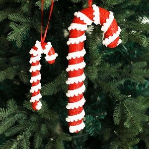 Red and white glitter candy cane ornaments hanging on a festive green Christmas tree