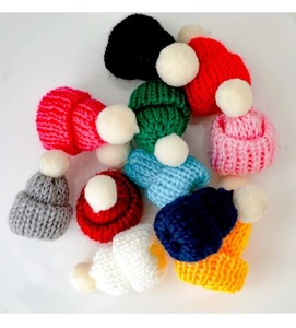 Bunte Mini-Strickmützen mit weißen Pompons für festliche Dekorationen von Weinflaschen