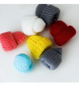 Nahaufnahme bunter Mini-Strickmützen für Weinflaschen und DIY-Weihnachtsdekoration